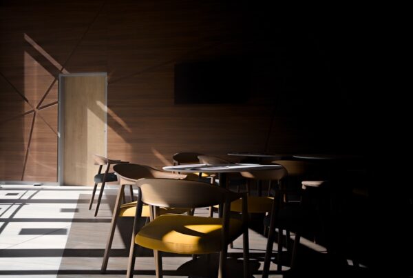 Chairs and tables in a room with dramatic light.